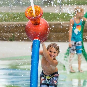 Child playing with Interactive Spray Feature for water play